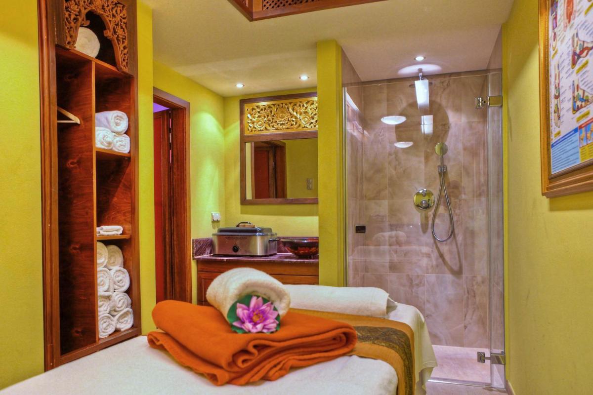 ein Bad mit einer Dusche und ein Bett mit einem Handtuch in der Unterkunft SEETELHOTEL Ahlbecker Hof das elegante Traditionshotel & ruhiger Rückzugsort an der Ostsee in Ahlbeck