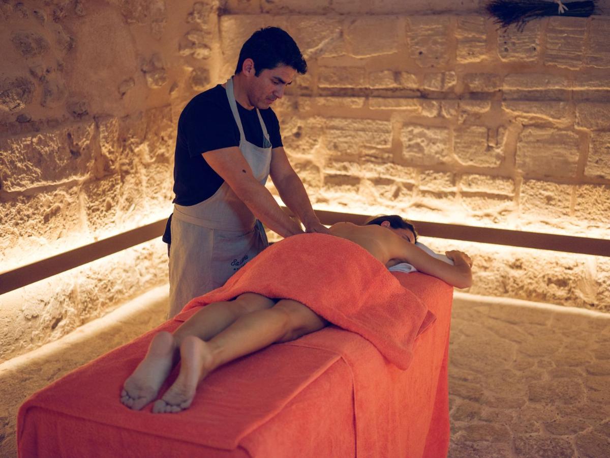 un hombre acostado en la parte superior de una cama con un hombre de pie en Hotel Gloria de Sant Jaume, en Palma de Mallorca