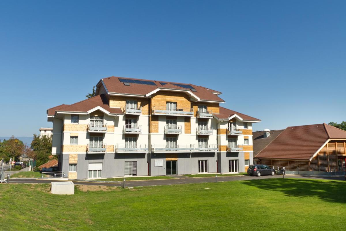un grand bâtiment blanc avec un toit marron dans l'établissement Villa Thermae Thonon-Les-Bains, à Thonon-les-Bains