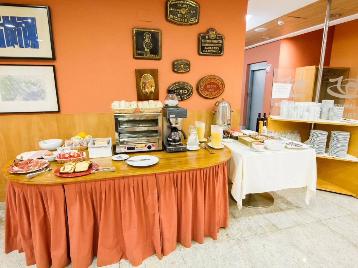 Una mesa con comida en un restaurante. en Hotel La Estación de Luanco, en Luanco