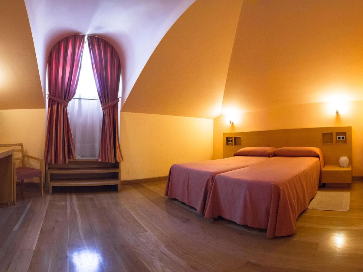 Un dormitorio con una cama grande y una ventana. en Hotel La Estación de Luanco, en Luanco