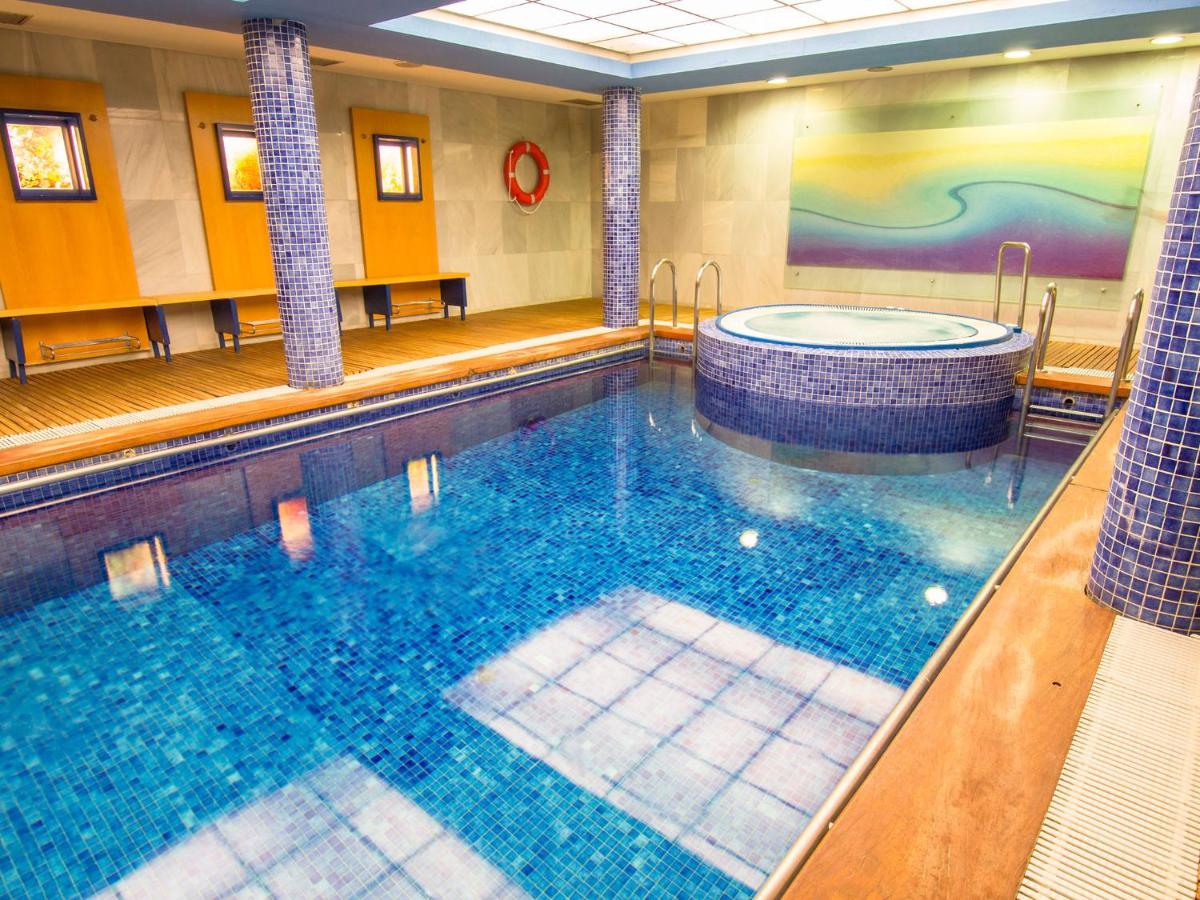 una gran piscina con bañera de hidromasaje en una habitación de hotel en Hotel La Estación de Luanco, en Luanco
