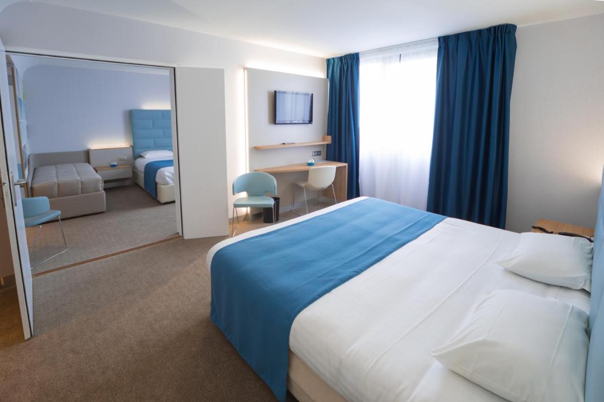 Un ou plusieurs lits dans un hébergement de l'établissement Hotel Plaza - site du Futuroscope