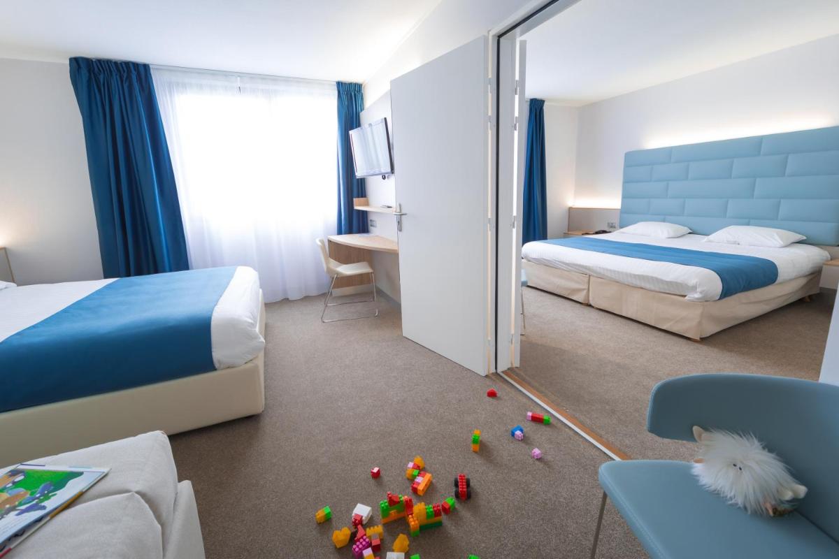 Un ou plusieurs lits dans un hébergement de l'établissement Hotel Plaza - site du Futuroscope