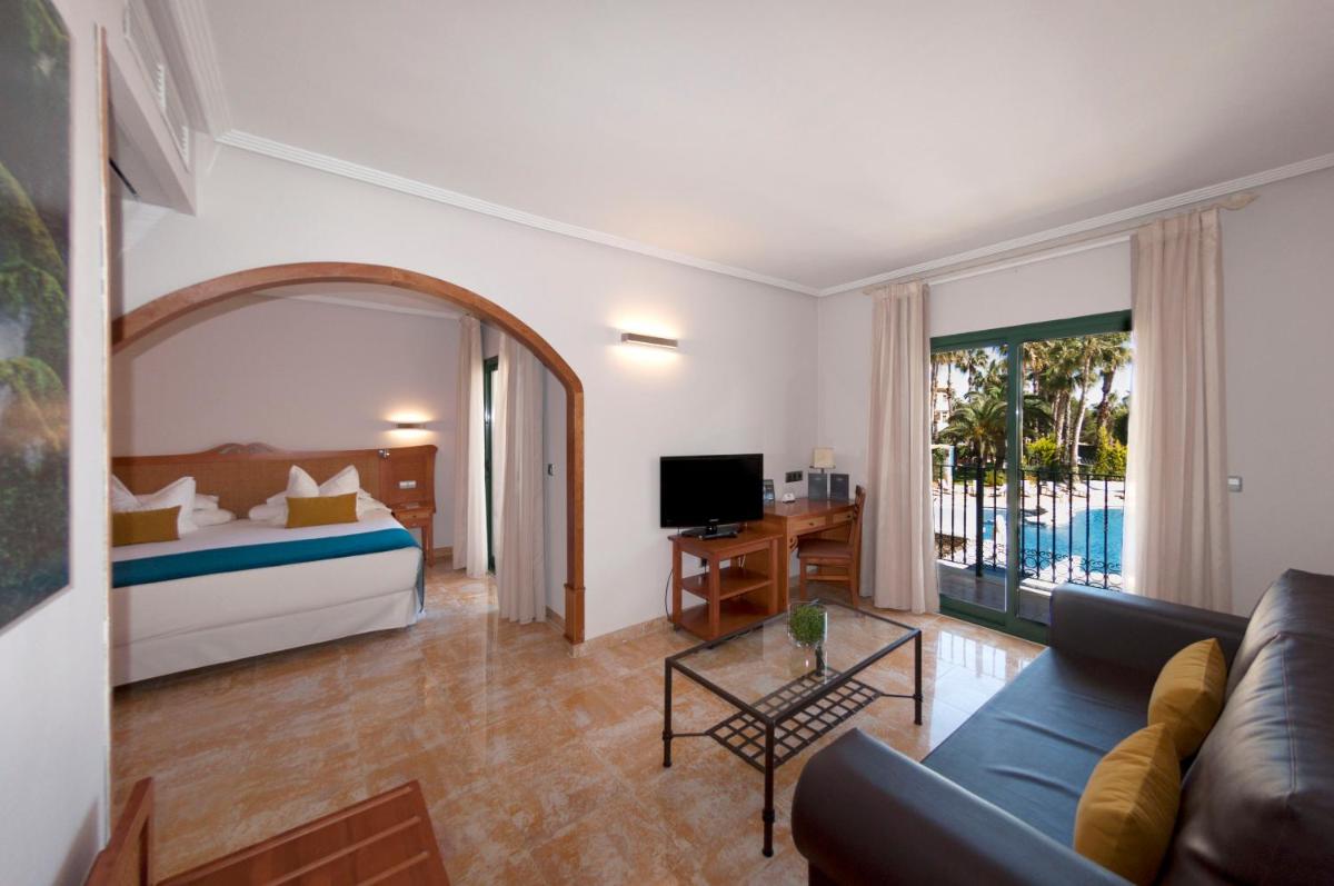 una sala de estar con una cama y un sofá en Hotel La Laguna Spa & Golf, en Torrevieja