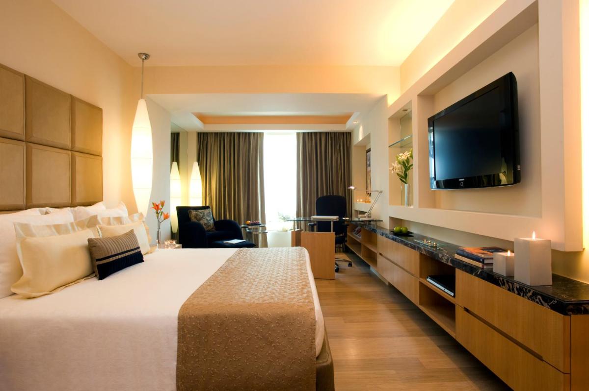 a hotel room with a bed and a flat screen tv at Taj Club House in Chennai