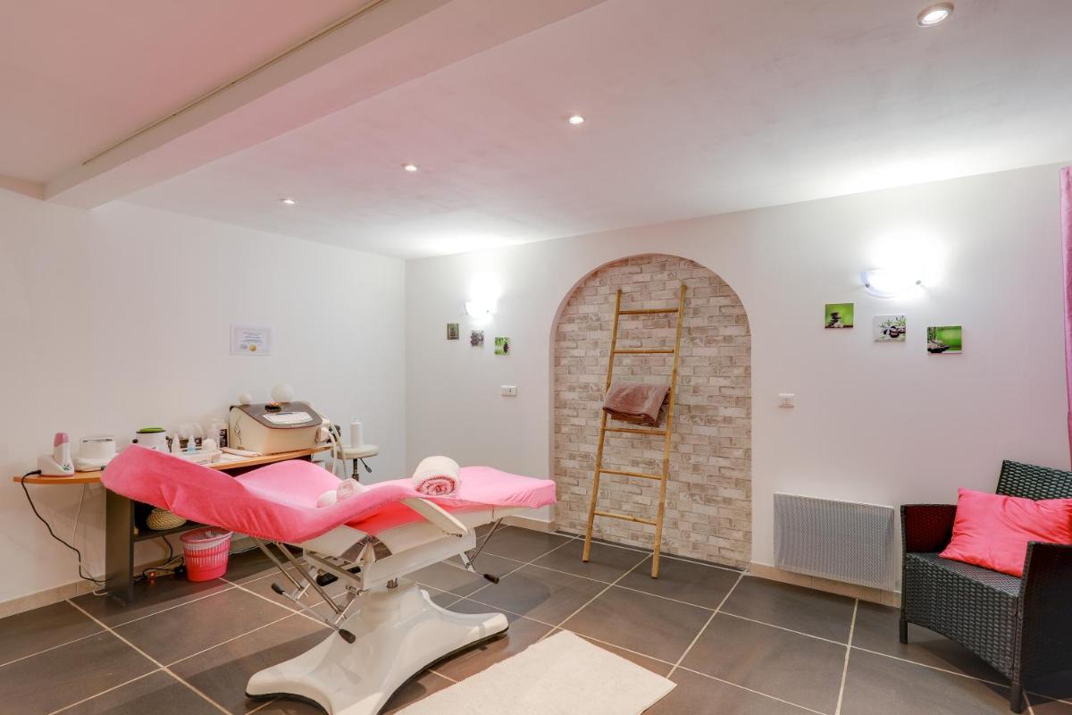 une chambre avec une chaise, une table et une échelle dans l'établissement Hôtel Spa L'Ermitage, aux Salles-sur-Verdon