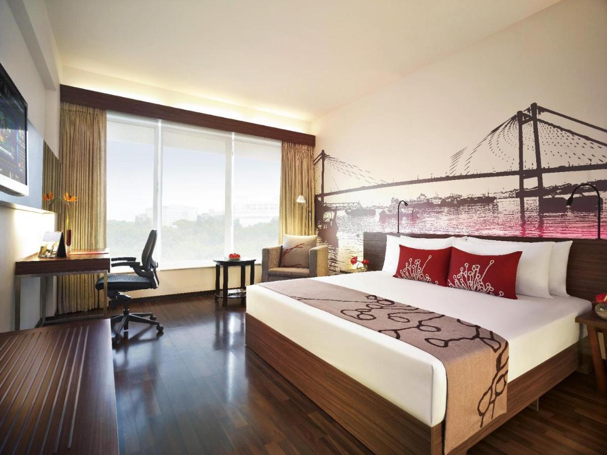 a hotel room with a bed and a desk at Vivanta Kolkata EM Bypass in Kolkata