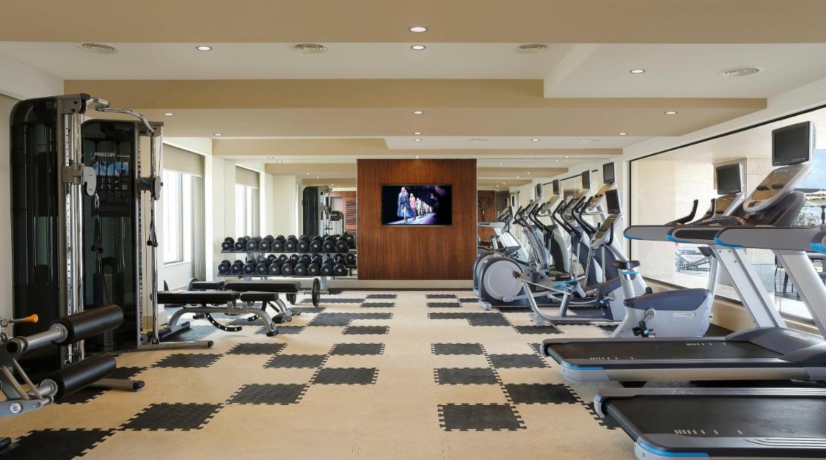 a gym with treadmills and cardio equipment in a building at Novotel Kochi Infopark in Cochin