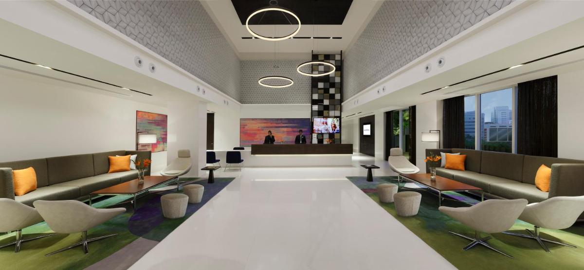 a lobby with couches and chairs in a building at Novotel Kochi Infopark in Cochin