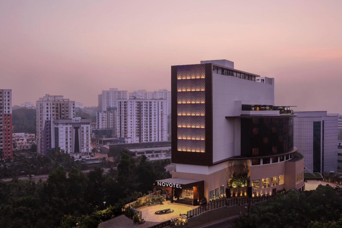 a hotel building with lights on it in a city at Novotel Kochi Infopark in Cochin