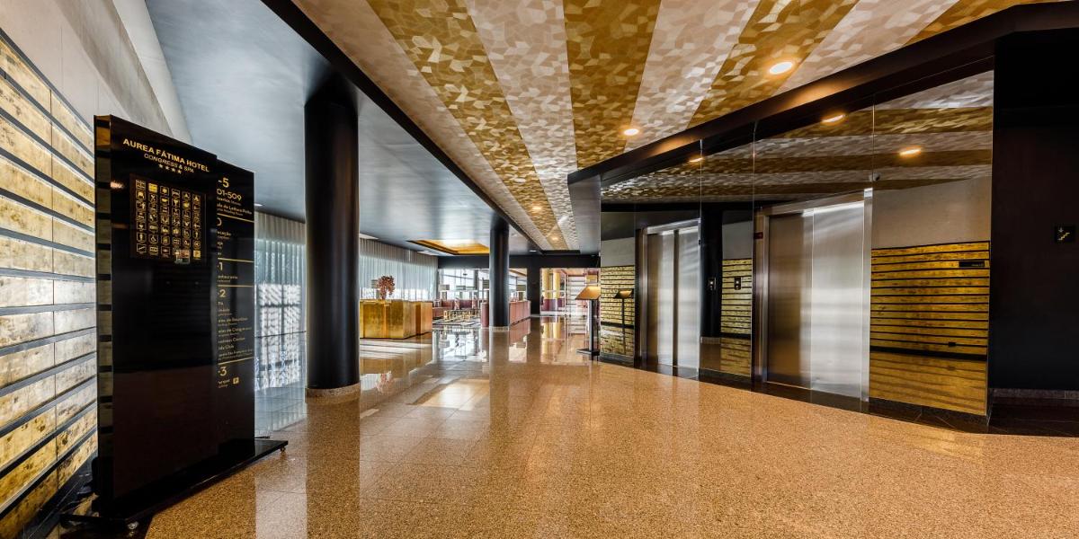 um corredor de um edifício com um sinal na parede em Aurea Fatima Hotel Congress & Spa em Fátima