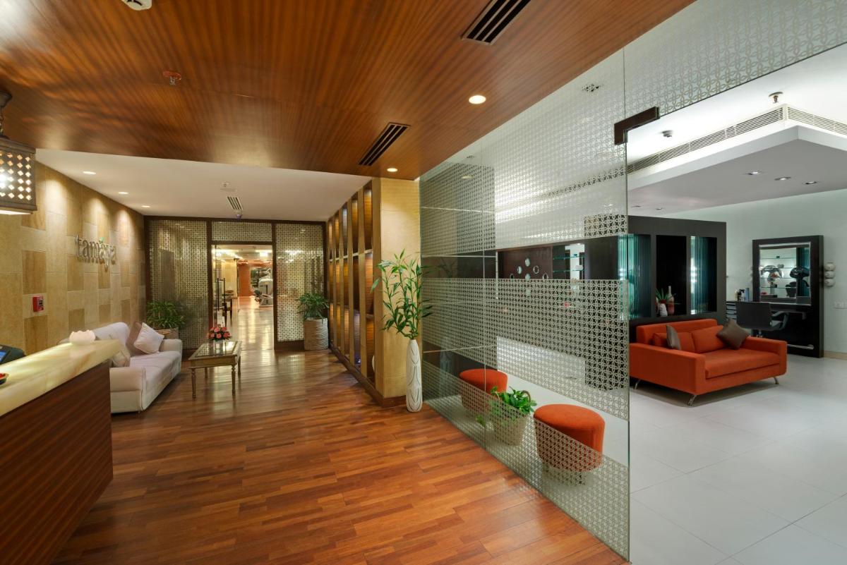 a hallway with a living room with orange furniture at Jaypee Palace Hotel in Agra