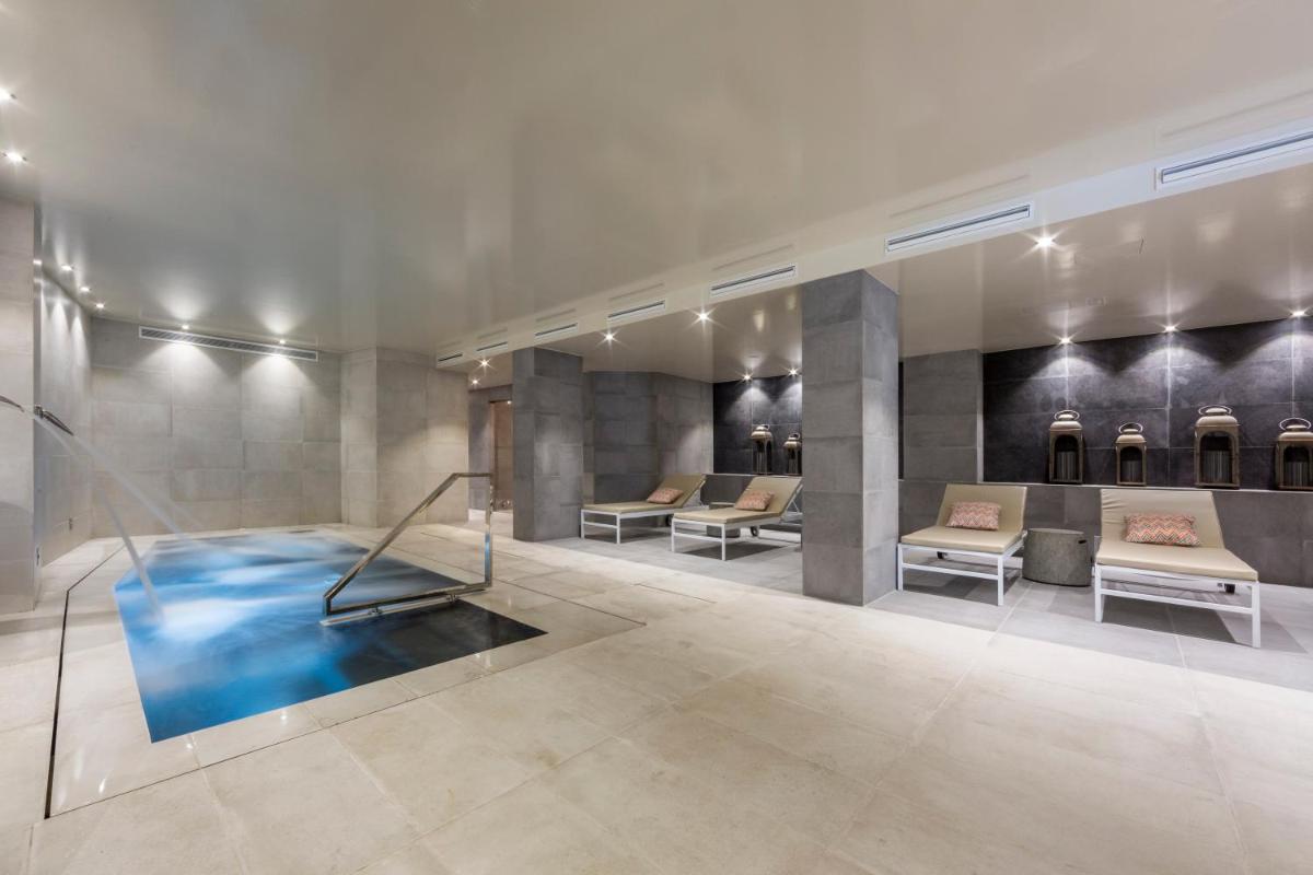 un vestíbulo con sofás y una piscina en una habitación en Catalonia Granada, en Granada