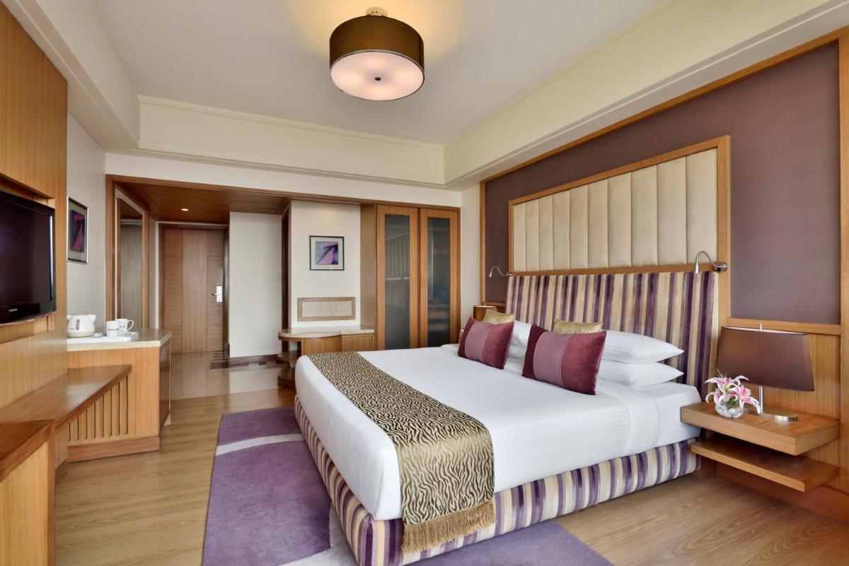 a hotel room with a bed and a flat screen tv at Radisson Blu Hotel, Indore in Indore