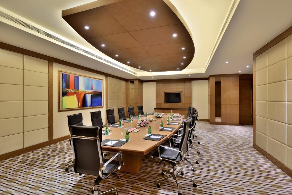 a large conference room with a long table and chairs at Radisson Blu Hotel, Indore in Indore