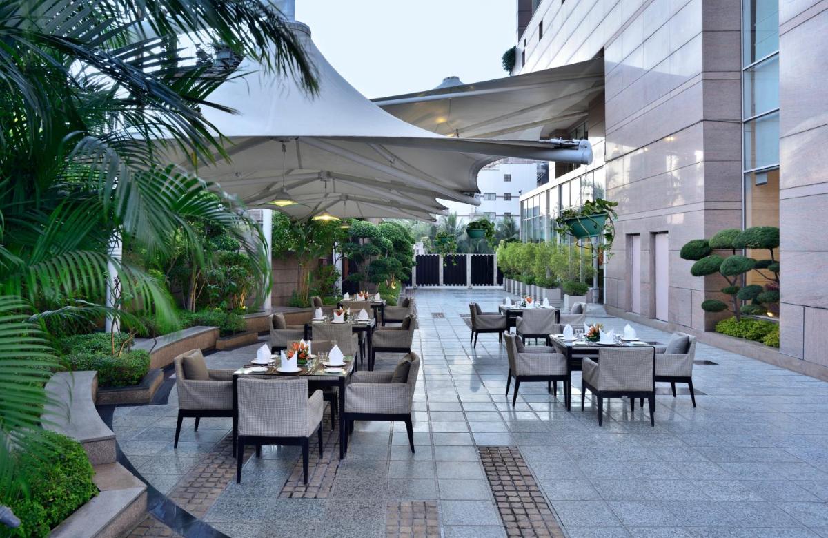 a restaurant with tables and chairs on a courtyard at Radisson Blu Hotel, Indore in Indore