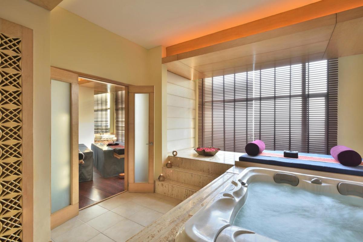 a bathroom with a jacuzzi tub next to a window at Radisson Blu Hotel, Indore in Indore
