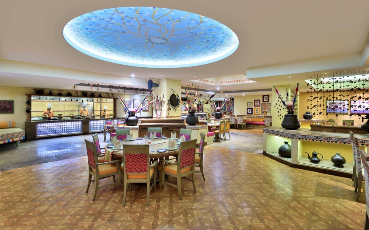 a restaurant with tables and chairs and a blue ceiling at Radisson Blu Hotel, Indore in Indore