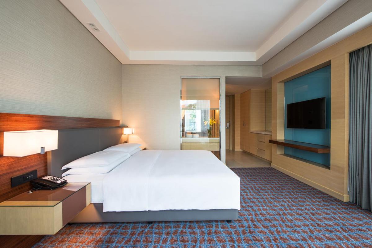 a bedroom with a large white bed and a television at Hyatt Regency Lucknow Gomti Nagar in Lucknow