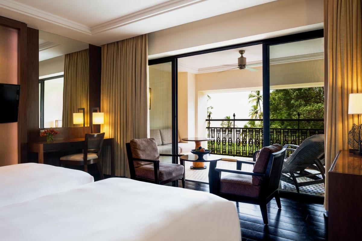a hotel room with two beds and a balcony at Grand Hyatt Goa in Panaji a hotel room with two beds and a balcony at Grand Hyatt Goa in Panaji