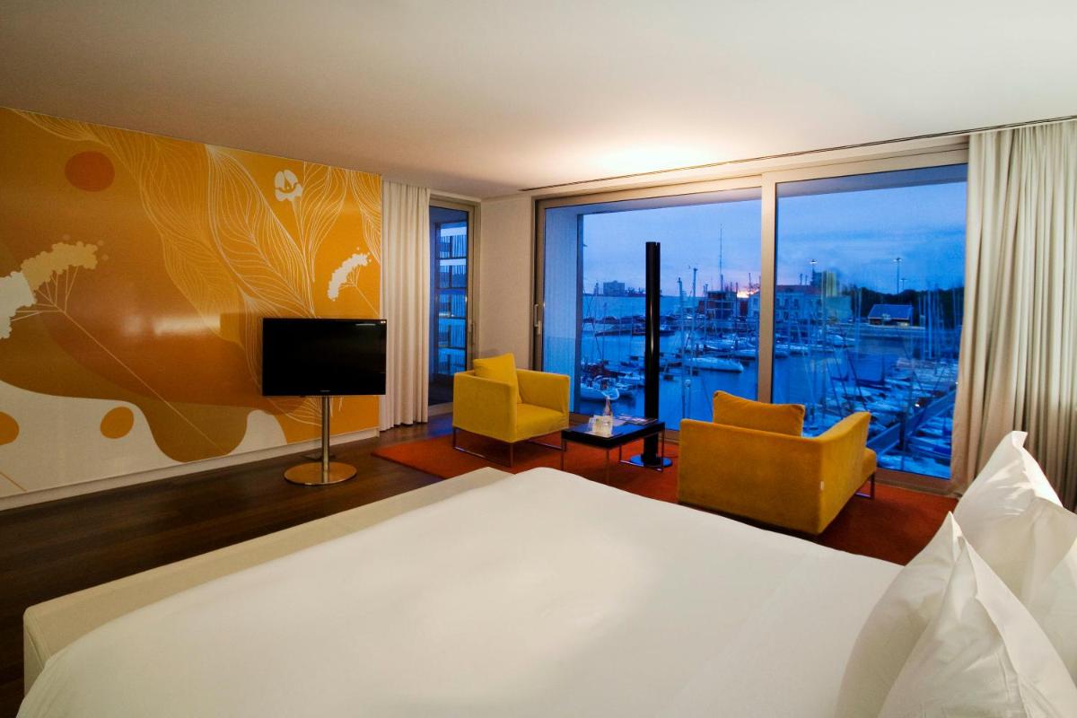 um quarto de hotel com uma cama e uma janela grande em Altis Belem Hotel & Spa, a Member of Design Hotels em Lisboa