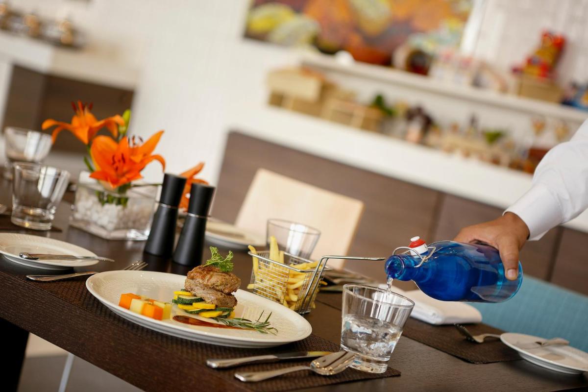 a person is preparing food on a table with a plate of food at Novotel Kochi Infopark in Cochin