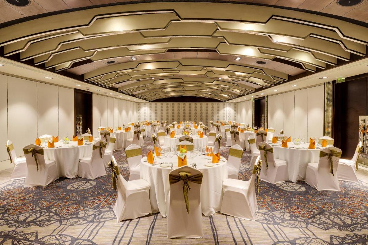 a banquet hall with white tables and chairs in it at Novotel Kochi Infopark in Cochin +55 photos