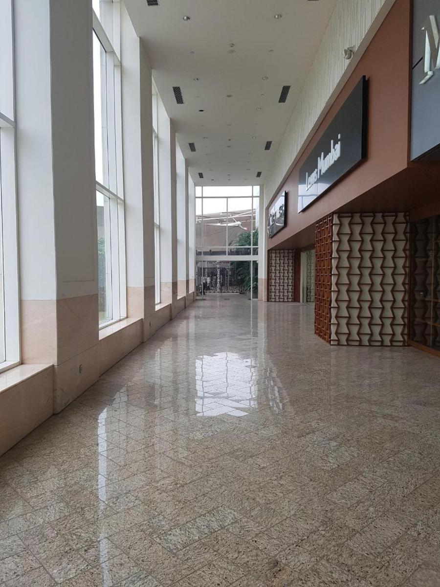 an empty hallway of a shopping mall with a sign at Taj Santacruz in Mumbai