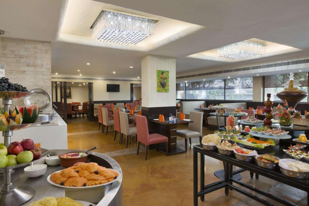 a buffet line with food on display in a restaurant at Ramada by Wyndham Chennai Egmore in Chennai a buffet line with food on display in a restaurant at Ramada by Wyndham Chennai Egmore in Chennai