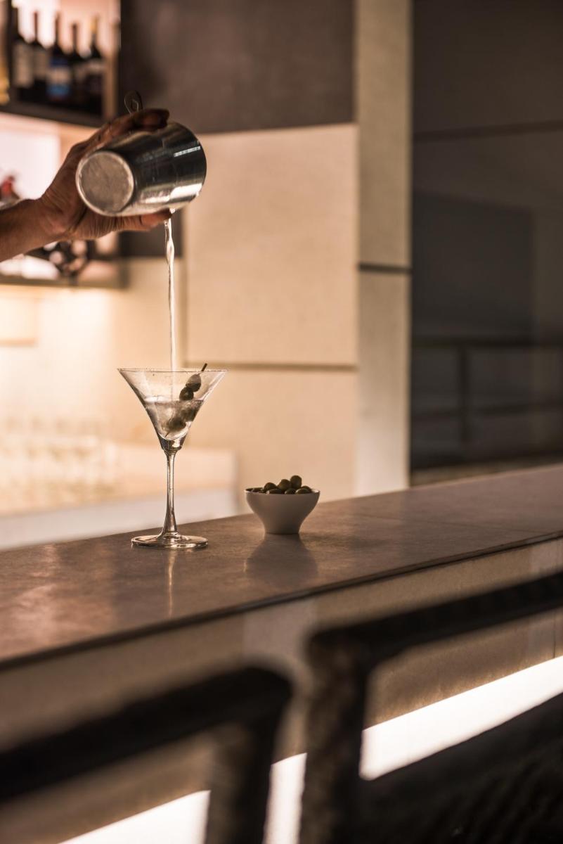 a person is pouring a drink into a martini glass at Hyatt Regency Lucknow Gomti Nagar in Lucknow