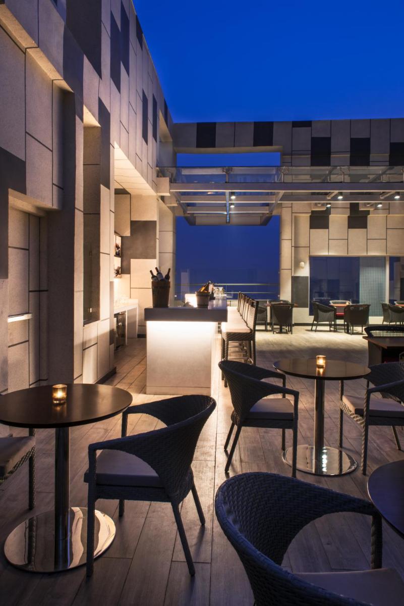 a restaurant with tables and chairs and a blue light at Hyatt Regency Lucknow Gomti Nagar in Lucknow