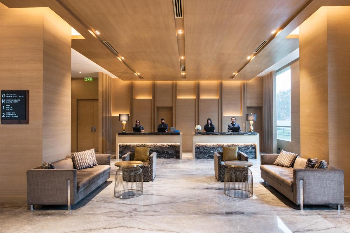 a lobby with couches and chairs in a building at Hyatt Regency Lucknow Gomti Nagar in Lucknow
