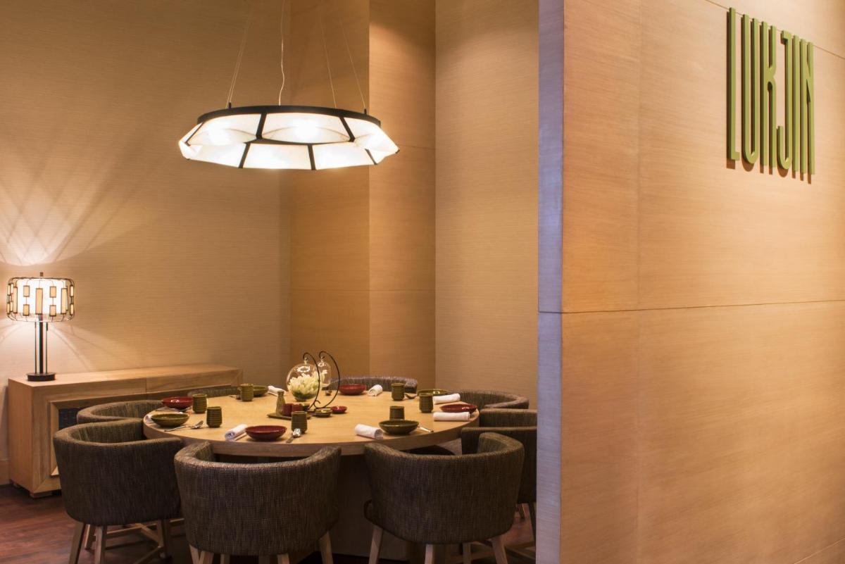 a dining room with a table and chairs at Hyatt Regency Lucknow Gomti Nagar in Lucknow