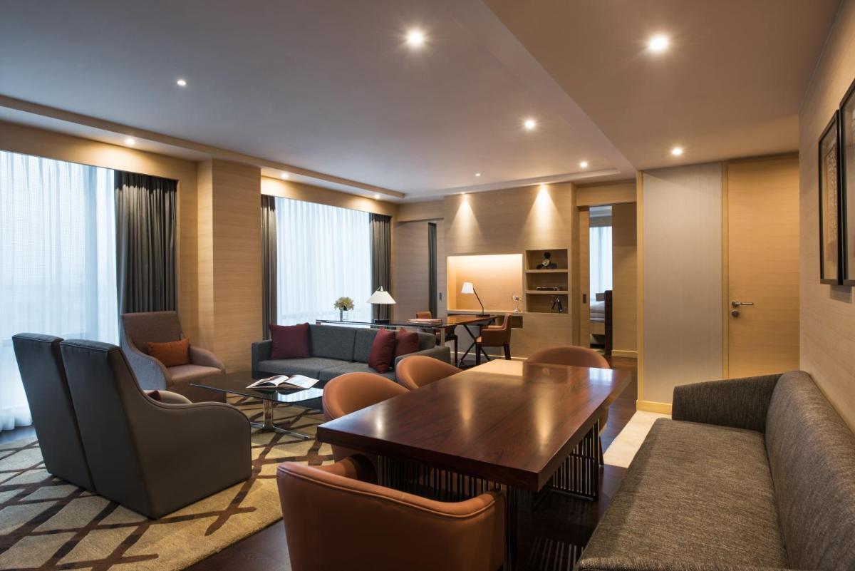 a hotel room with a couch and a table and chairs at Hyatt Regency Lucknow Gomti Nagar in Lucknow