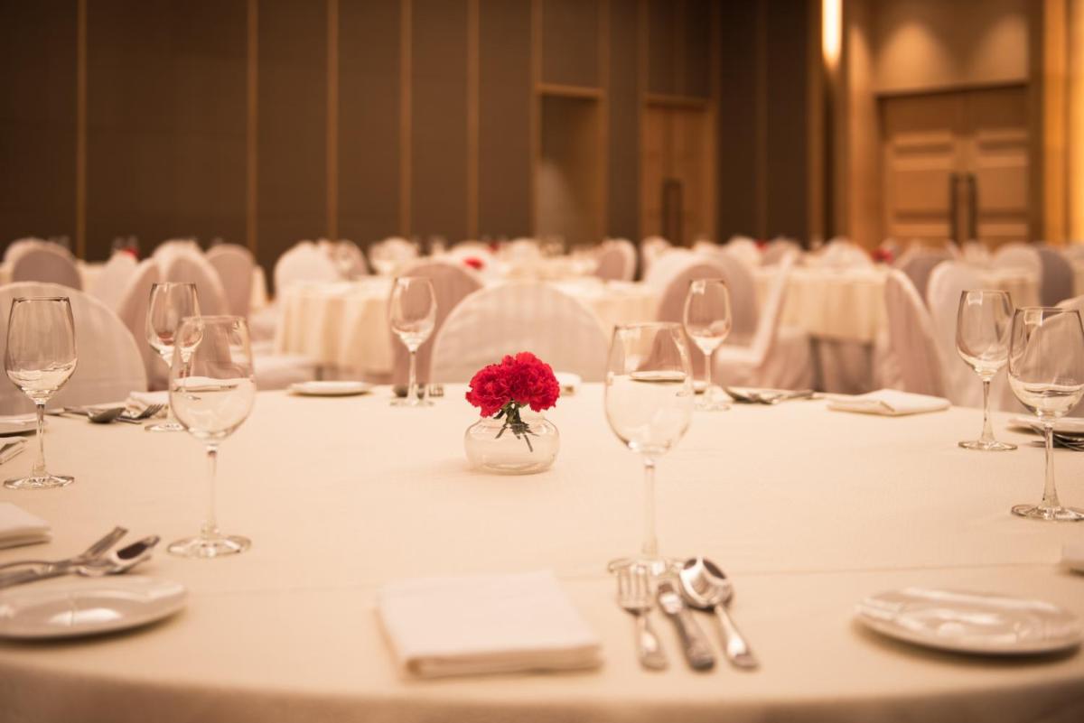 a table with wine glasses and a flower in a vase at Hyatt Regency Lucknow Gomti Nagar in Lucknow