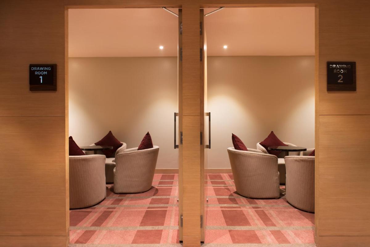 a waiting room with chairs and tables in a building at Hyatt Regency Lucknow Gomti Nagar in Lucknow