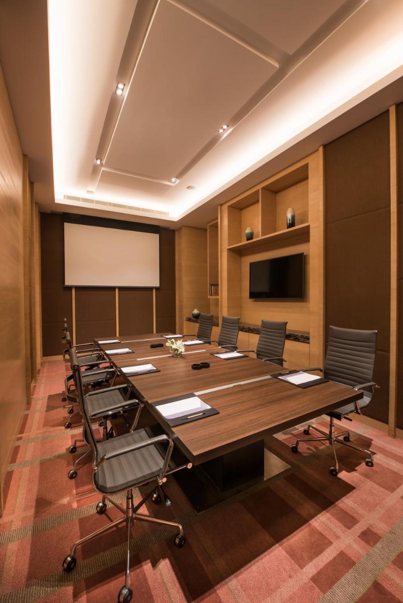 a conference room with a large wooden table and chairs at Hyatt Regency Lucknow Gomti Nagar in Lucknow
