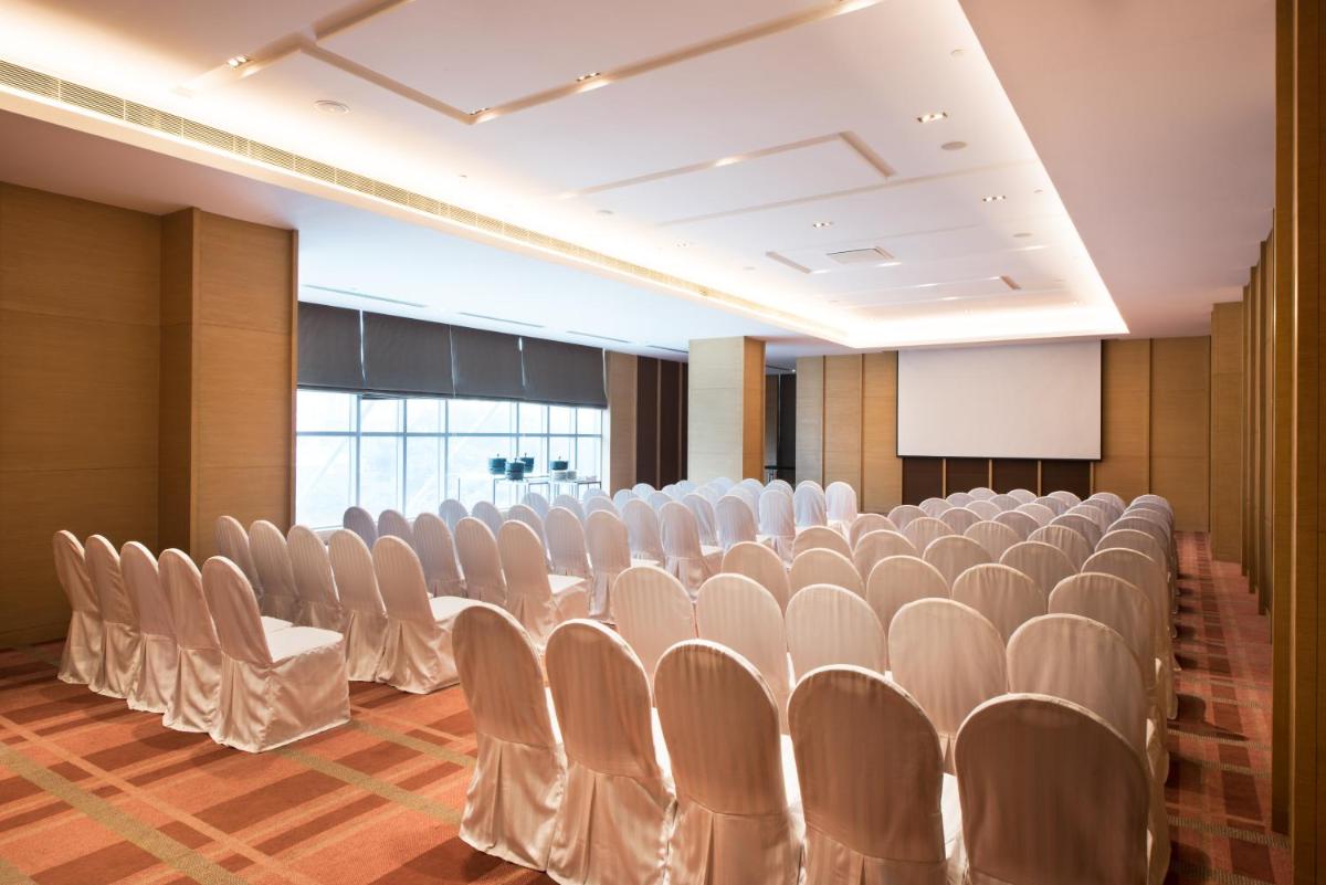 a conference room with white chairs and a podium at Hyatt Regency Lucknow Gomti Nagar in Lucknow