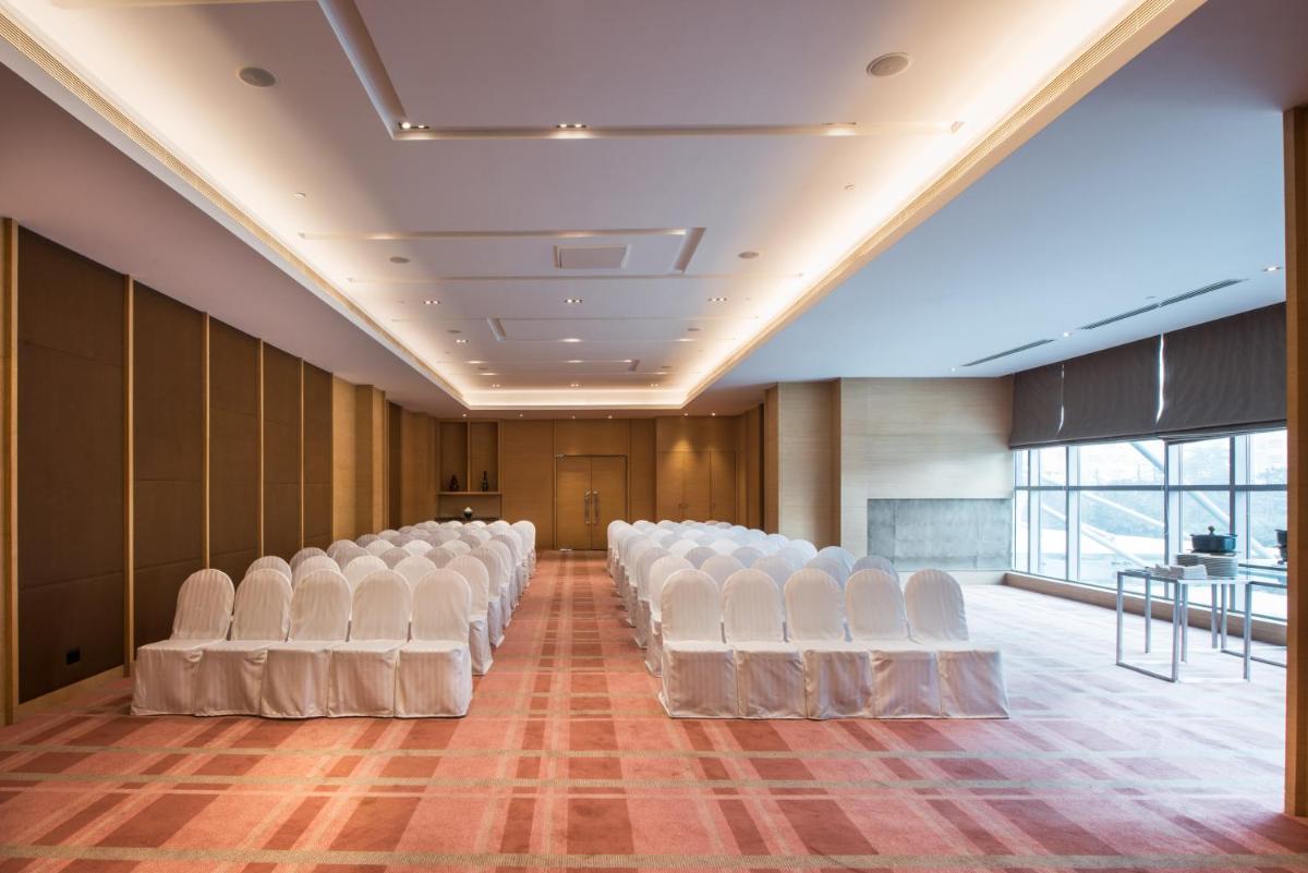 an empty room with white chairs in a building at Hyatt Regency Lucknow Gomti Nagar in Lucknow