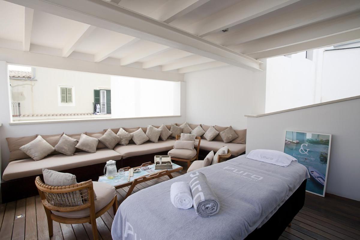 una habitación con un sofá y una cama y una mesa en Puro Hotel Oasis Urbano, en Palma de Mallorca 98 fotos más