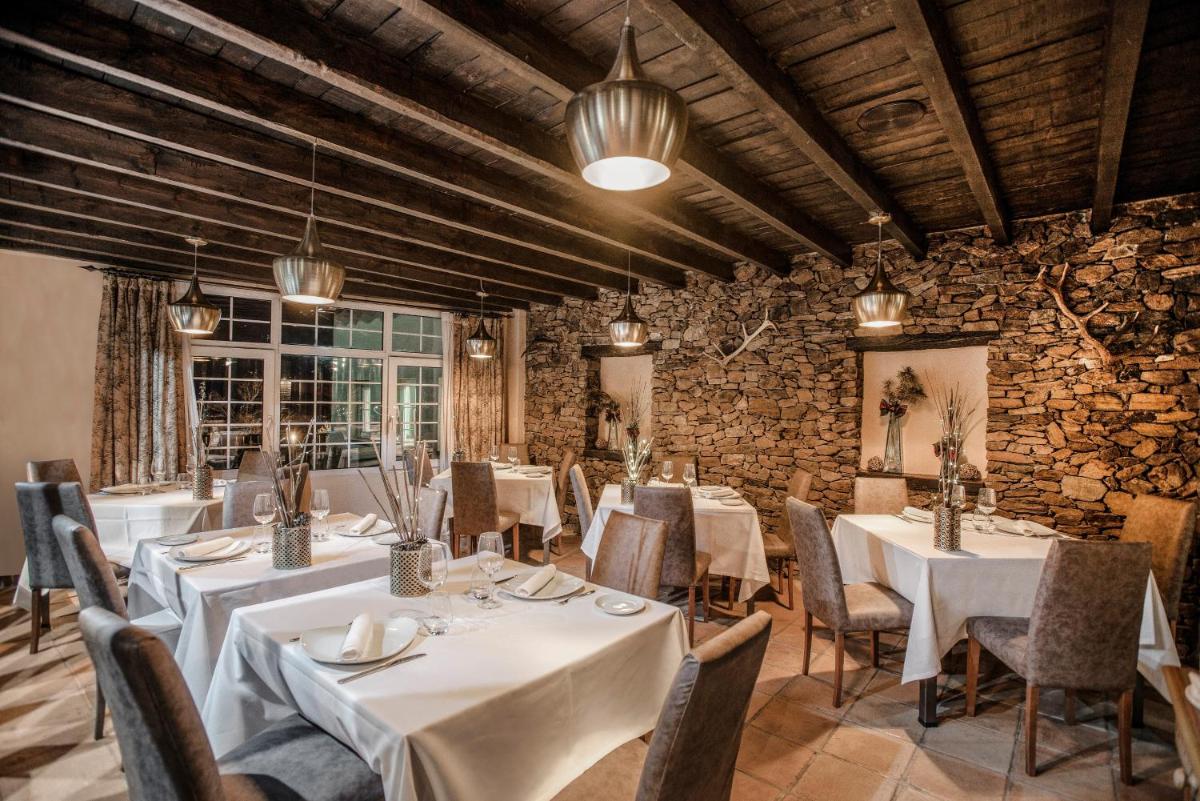 Un comedor con mesas y sillas blancas. en Vincci Selección Rumaykiyya, en Sierra Nevada