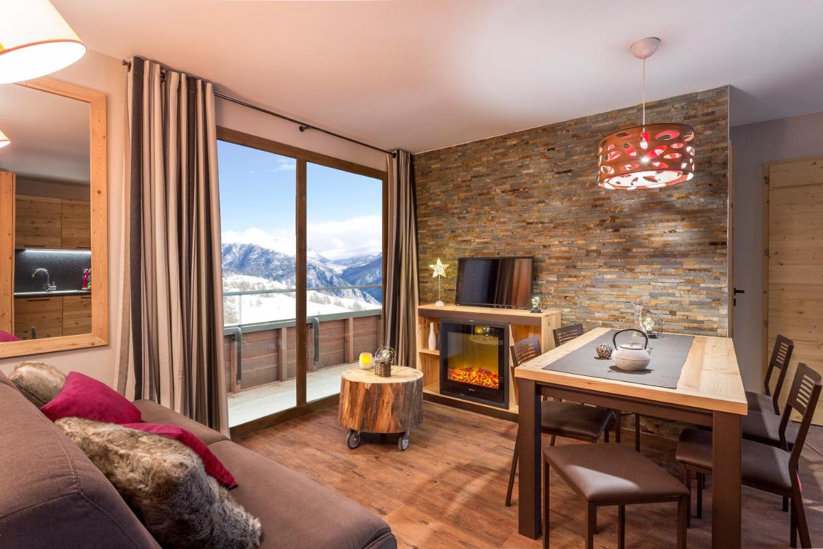 - un salon avec un canapé et une table avec une cheminée dans l'établissement Résidence Club MMV L'Altaviva, à Tignes