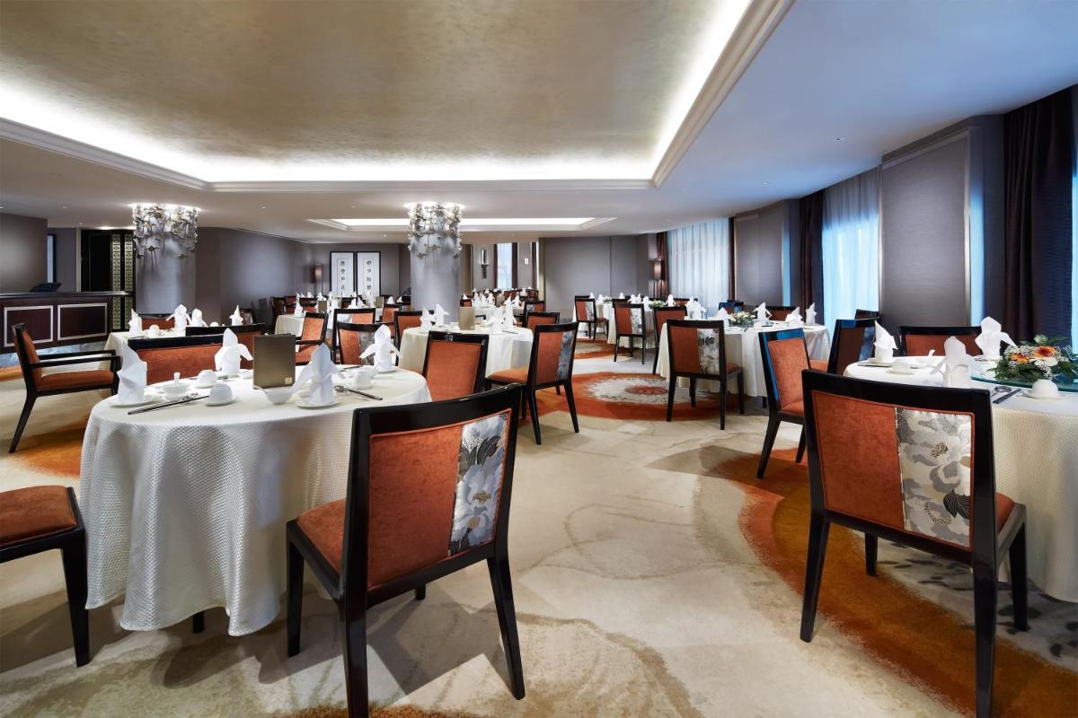 a dining room with tables and chairs in a restaurant at Carlton Hotel Singapore in Singapore a dining room with tables and chairs in a restaurant at Carlton Hotel Singapore in Singapore
