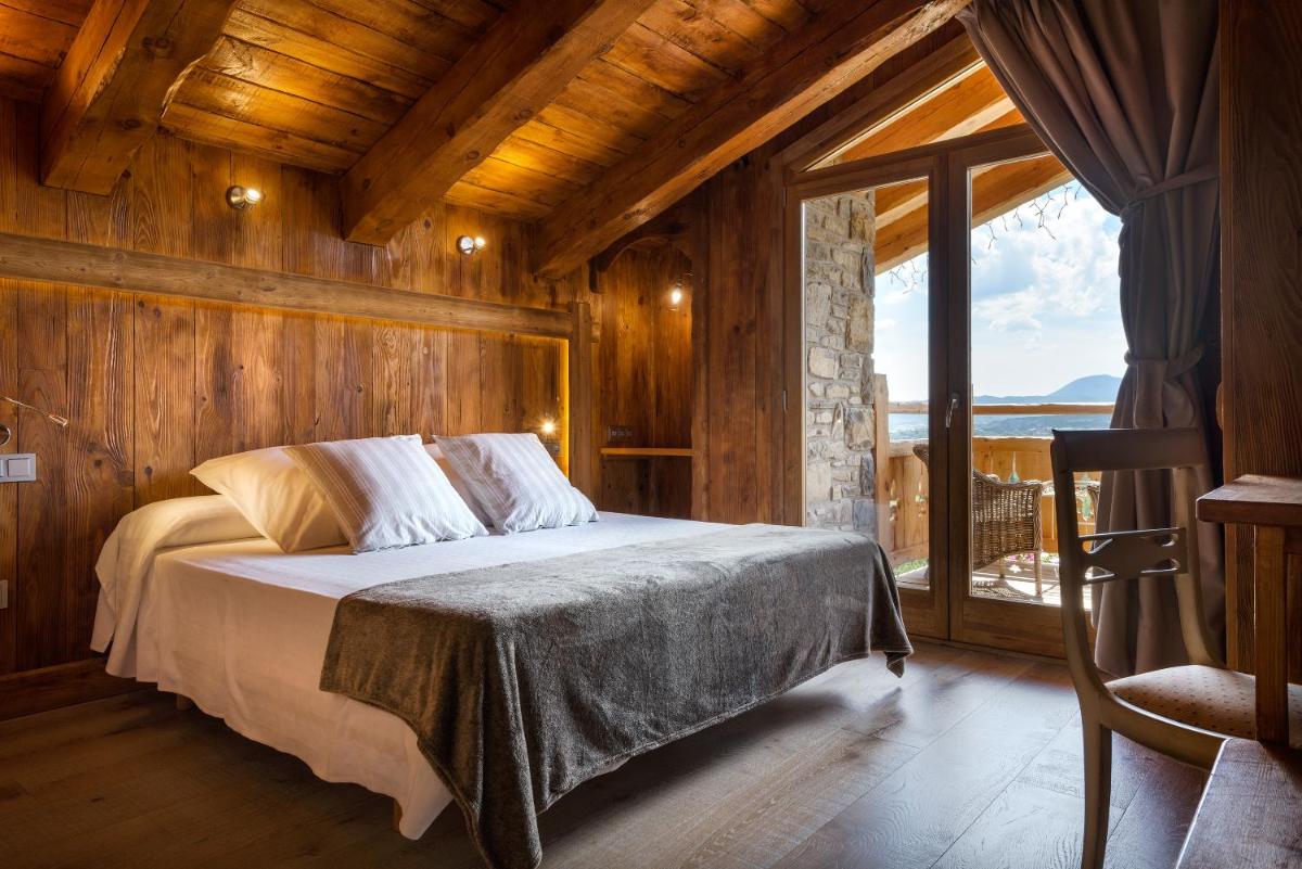 Un dormitorio con una cama y una ventana grande. en Hotel Viñas de Lárrede, en Lárrede