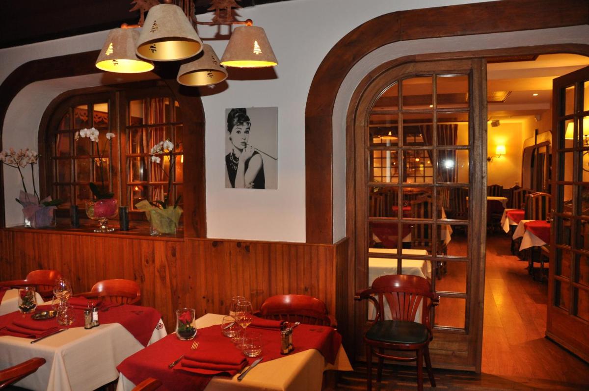 une salle à manger avec des tables et des chaises rouges dans un restaurant dans l'établissement Le Chalet Suisse, à Valberg