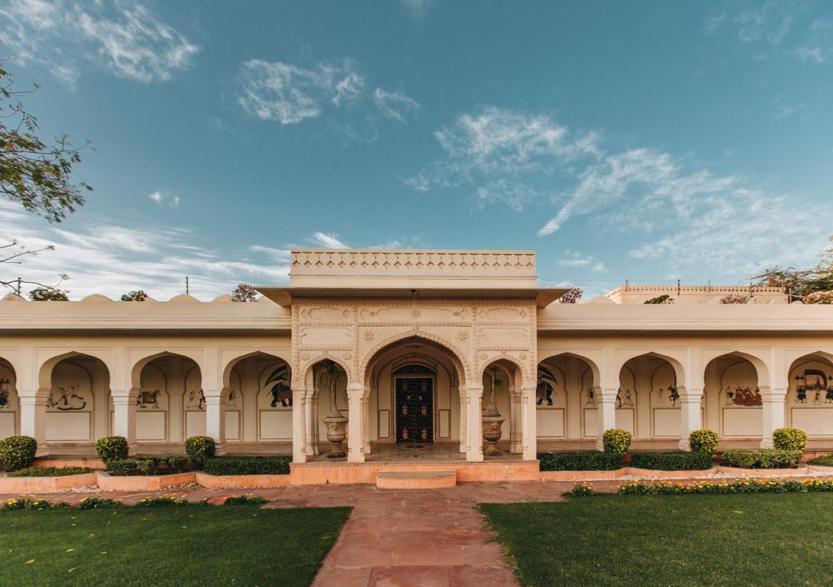 a large building with an archway in a yard at The Raj Palace (Small Luxury Hotels of the World) in Jaipur