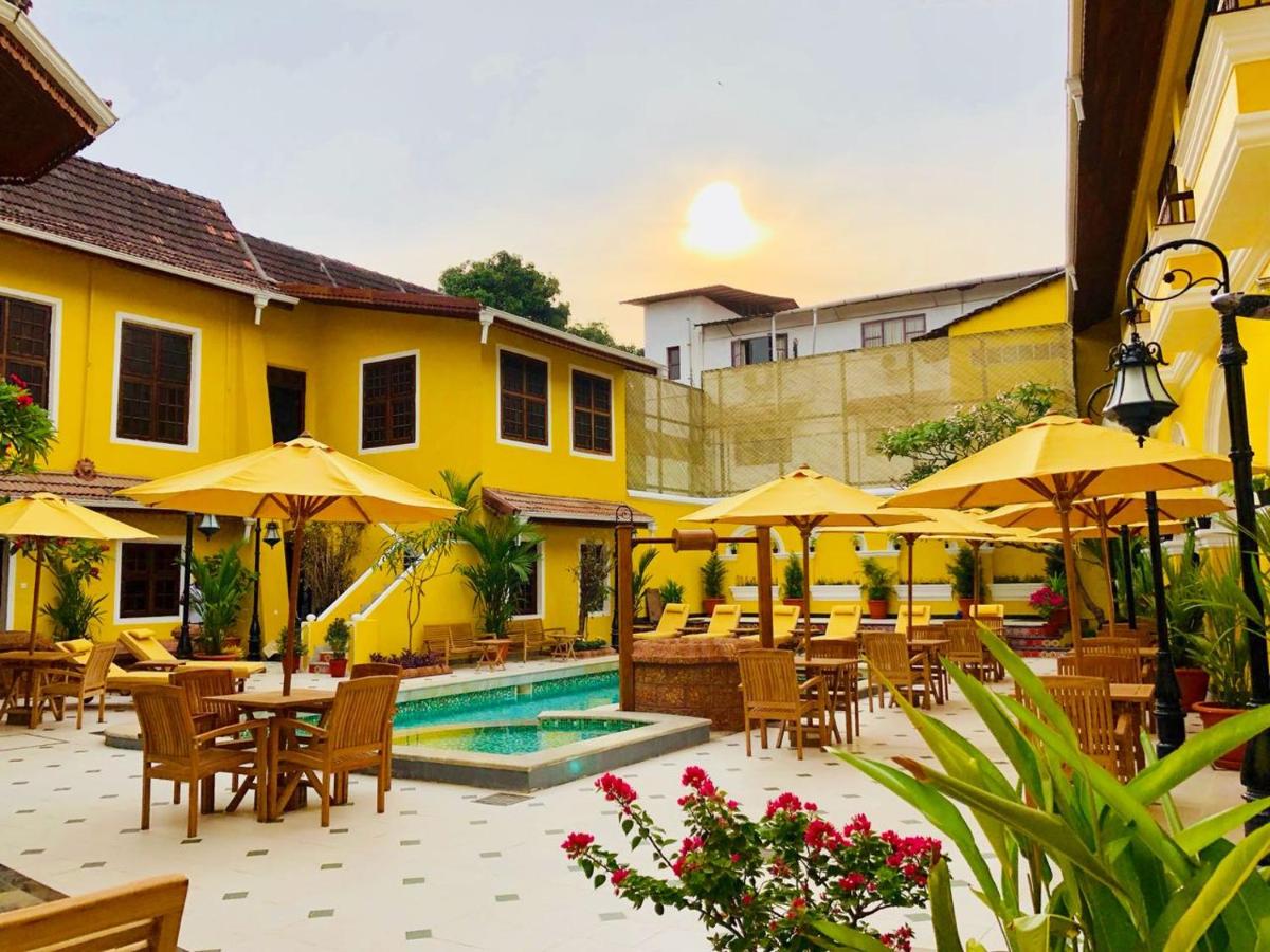 a resort with a pool and tables and umbrellas at Forte Kochi in Cochin
