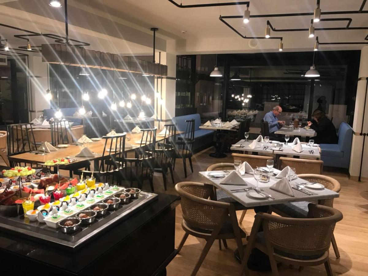 a restaurant with tables and chairs with food on display at Radisson Hotel Shimla in Shimla