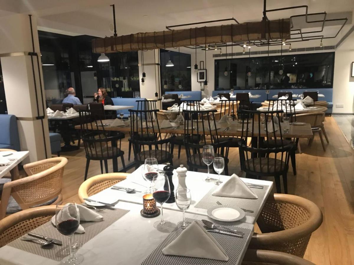 a dining room with tables and chairs in a restaurant at Radisson Hotel Shimla in Shimla